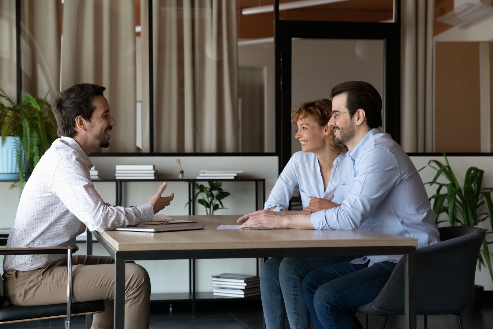Happy family couple of clients meeting with real estate agent